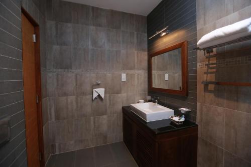 a bathroom with a sink and a mirror at Refresh Hotel Hikkaduwa in Hikkaduwa