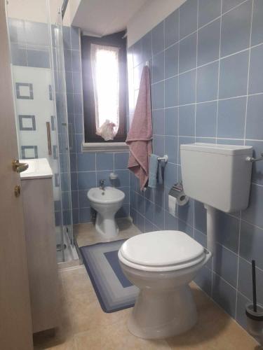 a blue tiled bathroom with a toilet and a sink at B&B da Maria & Renato il Lago Trattoria in Mirabella Eclano