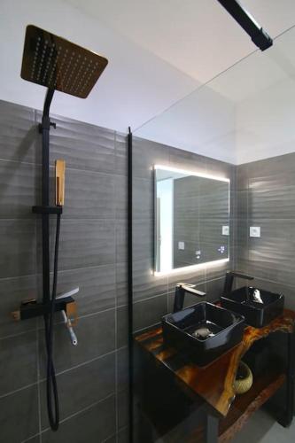 une salle de bain avec un lavabo noir et un miroir dans l'établissement Le Cap Marlou, vue mer exceptionnelle, à Saint-Mandrier-sur-Mer
