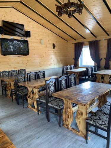 a dining room with wooden tables and chairs at Аура Карпат in Slavske