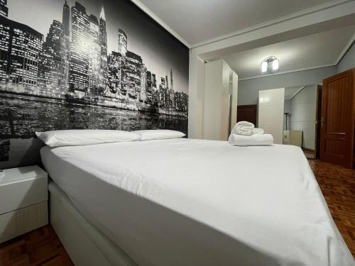 a bedroom with a large white bed with a wall mural at Encantador apartamento en el centro de Castro CON PARKING in Castro-Urdiales