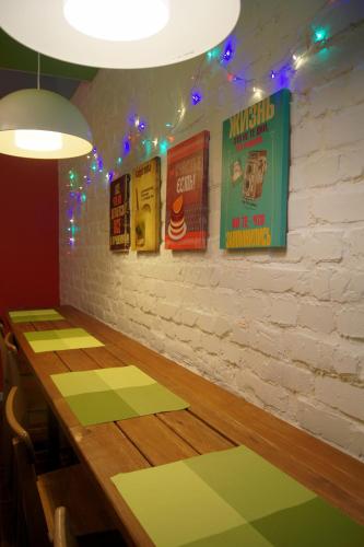 a dining room with a table and posters on the wall at Mini-Hotel Spi Zdes in Khabarovsk