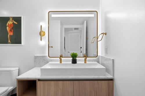 a bathroom with a white sink and a mirror at Ultimate Elegance Studio with Panoramic City Views in Miami