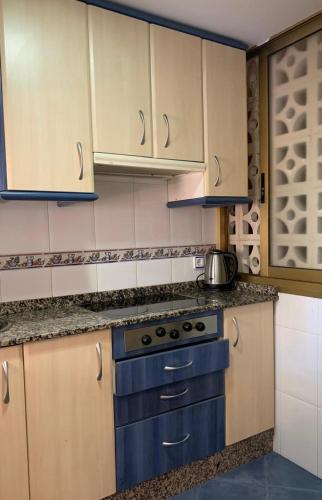 a kitchen with white cabinets and a stove top oven at Magic Summer Benidorm in Benidorm