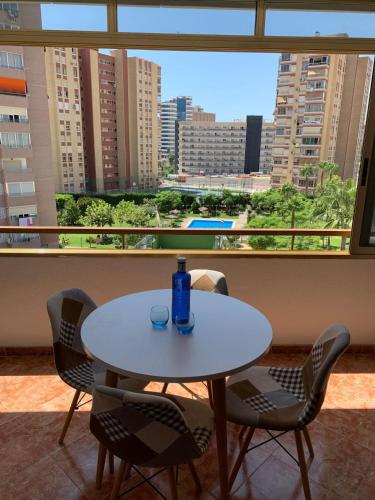 a table and chairs in a room with a large window at Magic Summer Benidorm in Benidorm