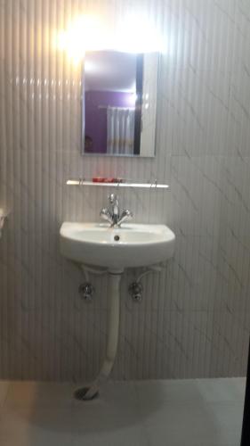 a white bathroom with a sink and a mirror at Siddhartha Garden Ayurveda in Pokhara