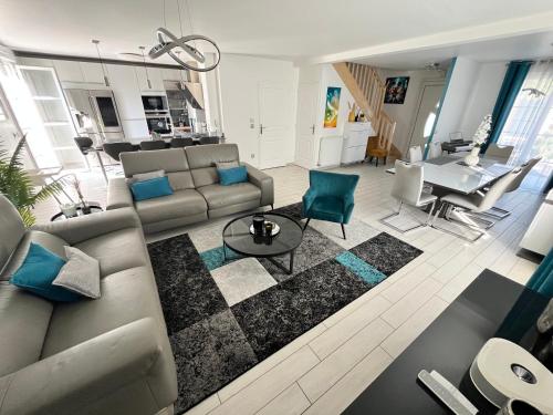 un salon avec un canapé et une table dans l'établissement Villa Spacieuse - Paisible - Moderne- 5' Disneyland, à Montévrain
