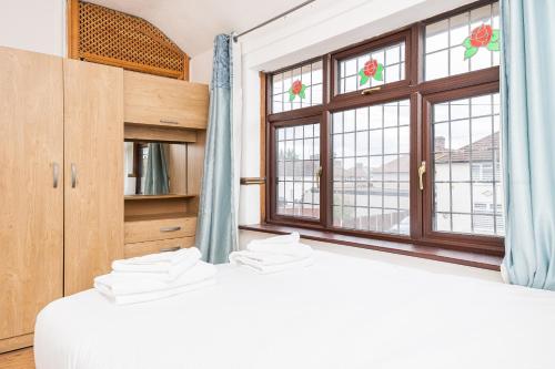 a bedroom with two beds and a window at DAGENHAM 3 and 4 BEDROOMS 2BATHS with Parking in Dagenham