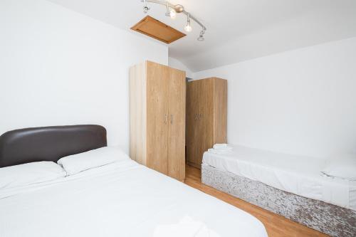 a bedroom with two beds and a closet at DAGENHAM 3 and 4 BEDROOMS 2BATHS with Parking in Dagenham