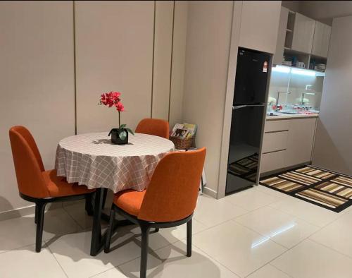 a kitchen with a table and chairs with a vase of flowers on it at H Residence Hill10 I-City in Shah Alam