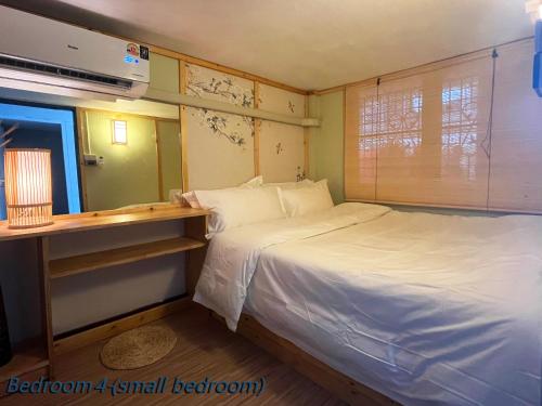a small bedroom with a bed and a desk at 曼谷市中心素坤逸4卧 泳池别墅 近nana 近Asoka in Bang Kapi