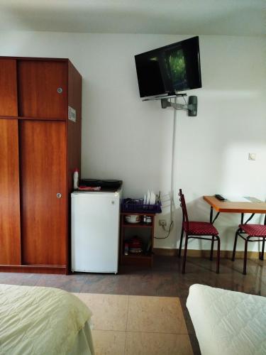 a room with a refrigerator and a tv on the wall at Mijovic Apartments in Budva