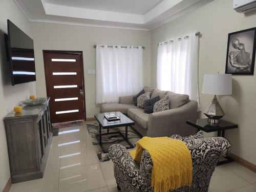 a living room with a couch and a table at Experience Luxury & Serenity-Your Perfect Getaway in Ocho Rios