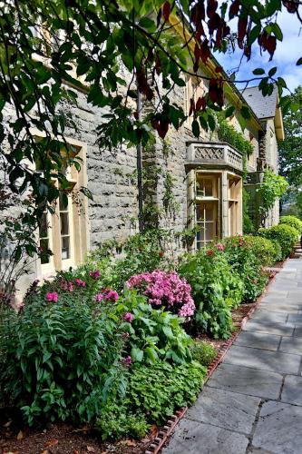 a house with a garden of flowers in front of it at Llangattock Park House in Crickhowell