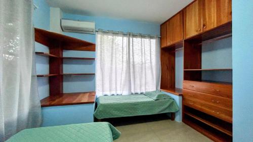 een slaapkamer met een bed en een raam en planken bij Casa independiente in Bahía de la Academia