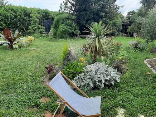 a chair sitting in the middle of a garden at Maison d'artiste in Saint-Quentin-de-Baron