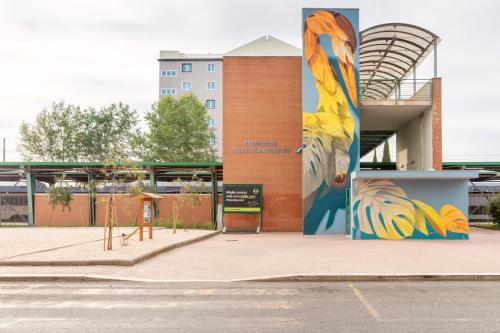a building with a mural on the side of it at B&B Hotel Roma Fiumicino Aeroporto Fiera 2 in Fiumicino