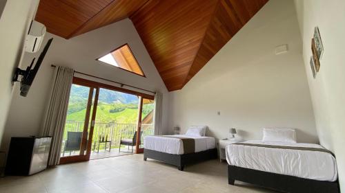 a bedroom with two beds and a window with a view at Göttlich Boutique Hotel in Pozuzo