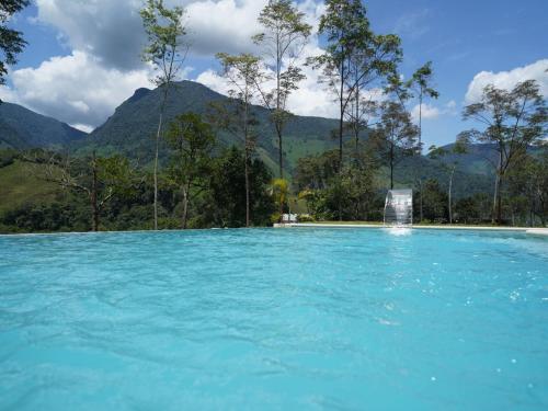a pool of blue water with mountains in the background at Göttlich Boutique Hotel in Pozuzo