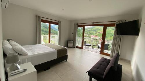 a bedroom with a bed and a chair and a balcony at Göttlich Boutique Hotel in Pozuzo