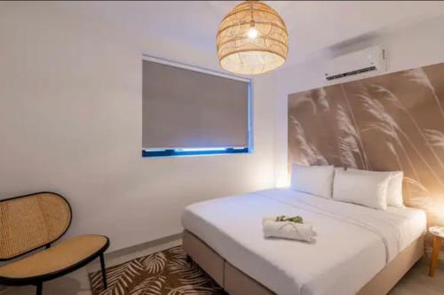 Un dormitorio con una cama y una silla y una ventana. en New apartments near the beach Jan Thiel Curacao, en Jan Thiel