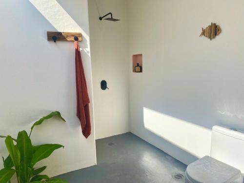 a bathroom with a red umbrella hanging on a wall at Kasa Koh in Brisas de Zicatela