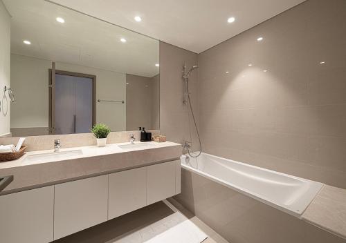 a bathroom with a sink and a tub and a mirror at Luxury Apartment with Full Burj Khalifa and Downtown Views in Dubai