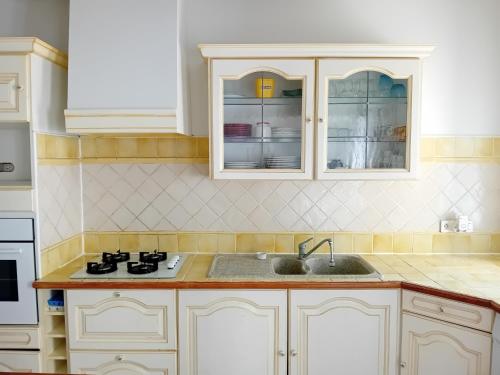 a kitchen with white cabinets and a sink at gîte appartement complet jusque 6 personnes in Cruis