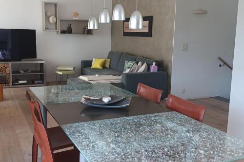 a living room with a table and a couch at Villa de charme élégante, calme, nature in Boudry