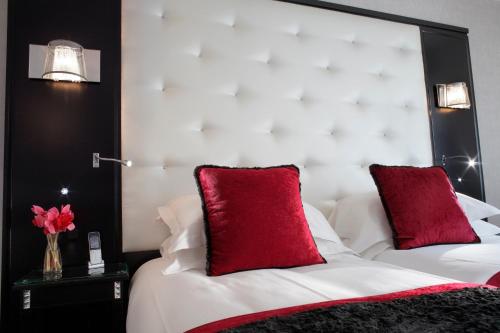 a bedroom with two red pillows on a bed at Maison Albar - Le Diamond in Paris