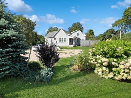 a white house with a yard with flowering bushes at Long Sands Your All-Season GetAway Brought to you by GetAway Vacations in York