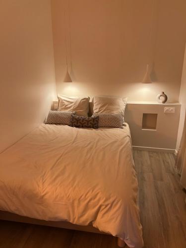 un lit avec des draps blancs et des oreillers dans une chambre dans l'établissement Au coeur du vieil Antibes, à Antibes