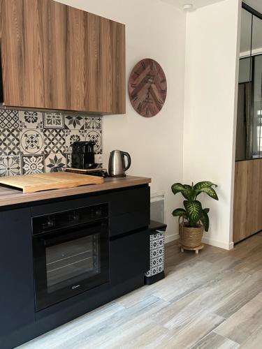 une cuisine avec un four noir et une horloge murale dans l'établissement Au coeur du vieil Antibes, à Antibes