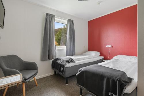 a room with two beds and a chair and a window at Skagi Bed & Lodge in Skaland