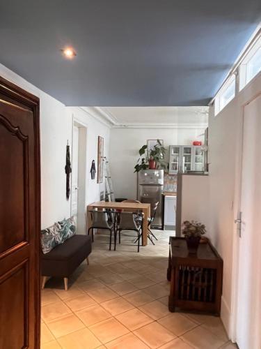 un salon avec une table et une cuisine dans l'établissement Vivre au Village des Batignolles, à Paris
