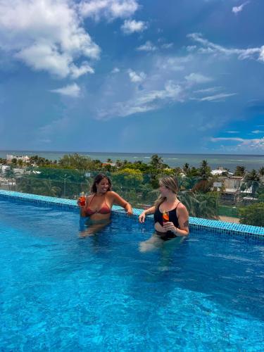 two women in the water in a swimming pool at Areia Boutique Hotel - Puerto Morelos in Puerto Morelos