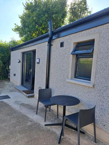 a table and chairs in front of a building at Cavehill Cottage in Belfast