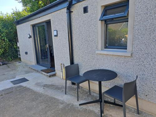 a table and chairs in front of a house at Cavehill Cottage in Belfast