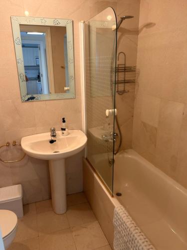 Un baño con lavabo, bañera y ducha. en Los Nidos, en Torremolinos
