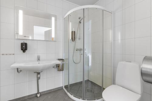 a bathroom with a shower and a sink and a toilet at Skagi Bed & Lodge in Skaland