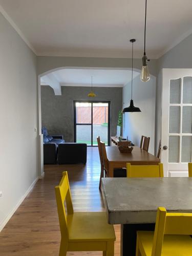 a dining room and living room with a table and chairs at Casa Aconchego - T2 in Espargos