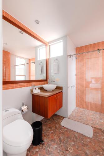 a bathroom with a toilet and a sink and a shower at Hotel Parque 63 in Bogotá