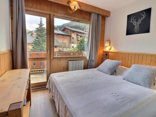 une chambre avec deux lits et une grande fenêtre dans l'établissement Grand 3 pièces avec balcon sud, Méribel - FR-1-182-192, à Les Allues