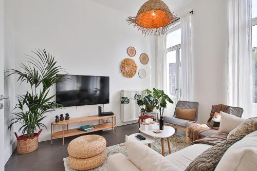 a living room with a couch and a tv at La bulle bohème - Entièrement neuf, près de Spa in Verviers