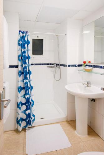 a white bathroom with a shower and a sink at Hotel San Miguel in Altea