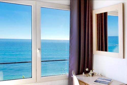 a room with a window with a view of the ocean at Hotel San Miguel in Altea