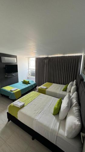 two beds in a hotel room with two beds at Hotel Tupinamba Neiva in Neiva