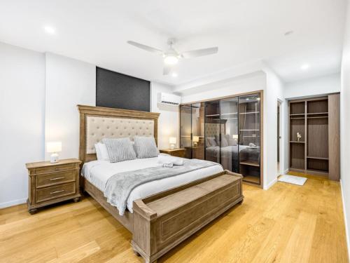 Un dormitorio con una cama grande con suelo de madera. en Luxury 4BR Cozy Home Pool, Gym, Sauna, wParking at CBD, en Brisbane