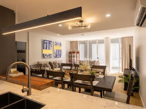 a kitchen and living room with a table and chairs at Luxury 4BR Cozy Home Pool, Gym, Sauna, wParking at CBD in Brisbane