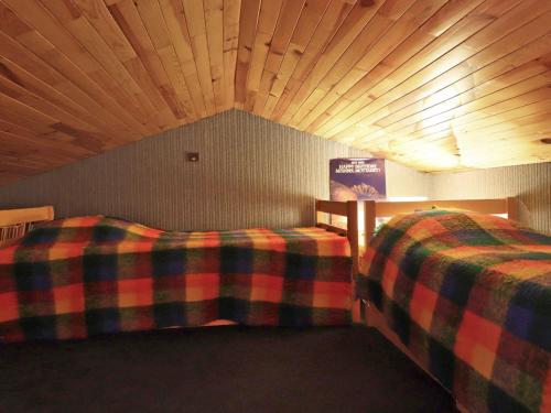 deux lits dans une chambre avec un plafond en bois dans l'établissement Charmant studio mezzanine skis aux pieds à Méribel, balcon, Wi-Fi, non fumeur - FR-1-182-234, à Les Allues